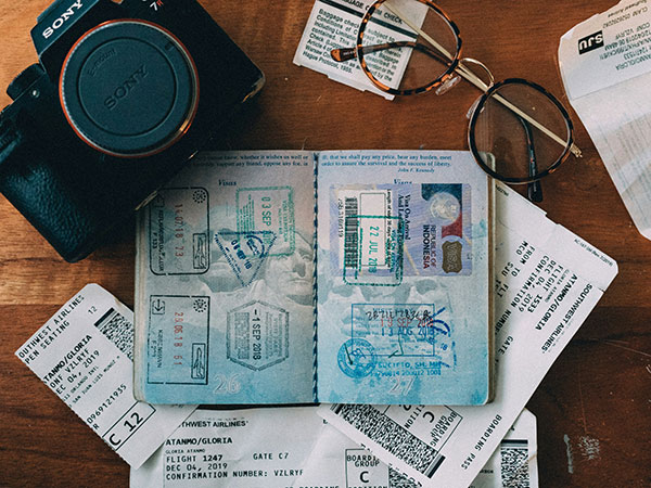 flatlay of passport, camera and other travel items