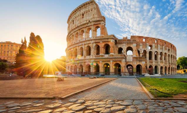 in front of the the Colloseum in rome at sunset