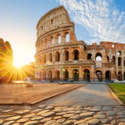 in front of the the Colloseum in rome at sunset