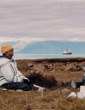 Local woman sits in the grasslands of Gjoa Haven / Uqsuqtuuq