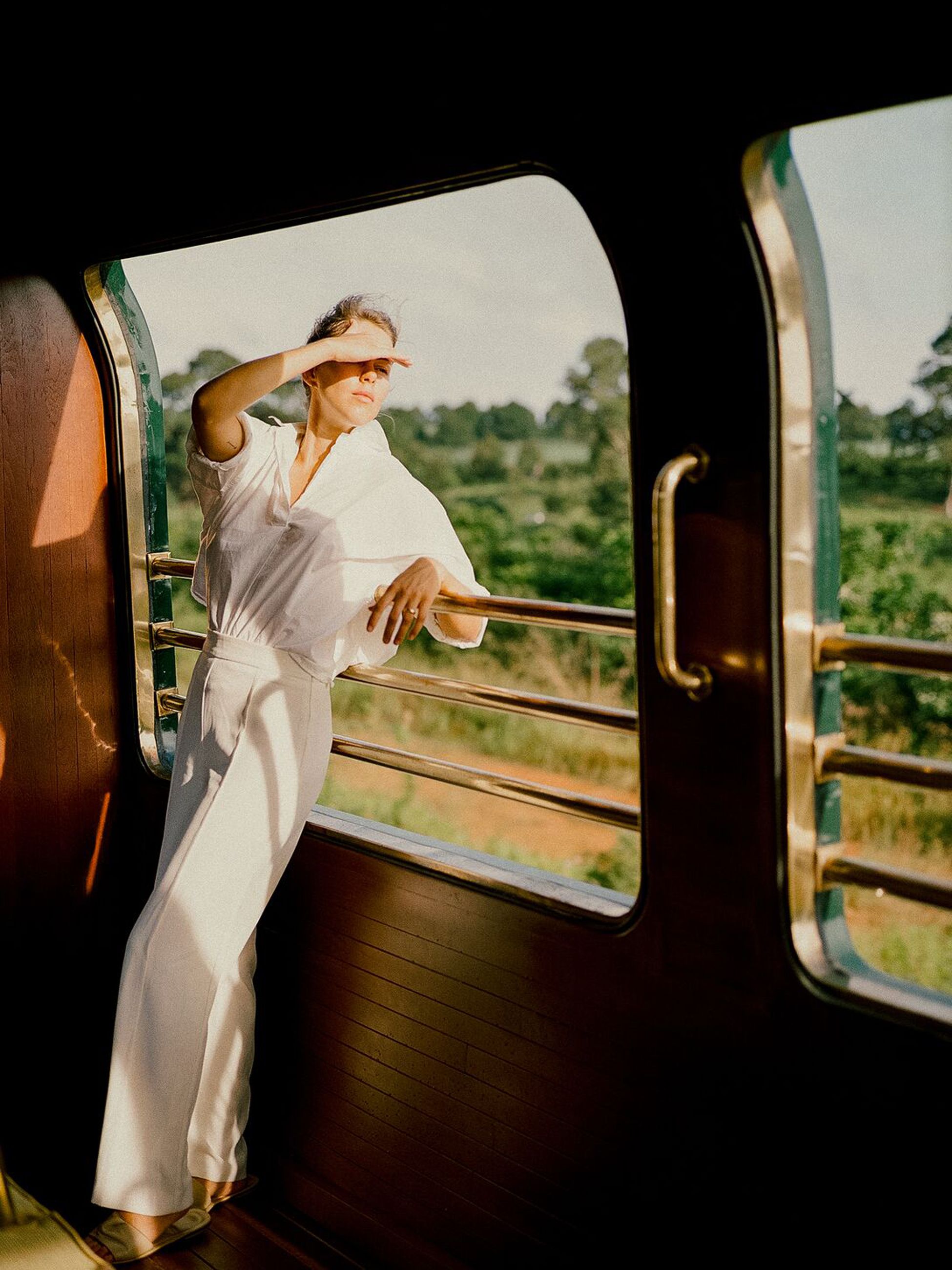 A woman onboard Eastern & Oriental Express, A Belmond Train, through Southeast Asia.