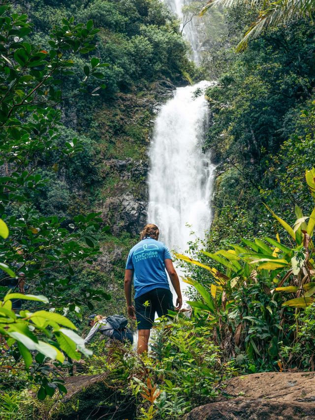 UnCruise tour leader in front of Hawaii Waterfall