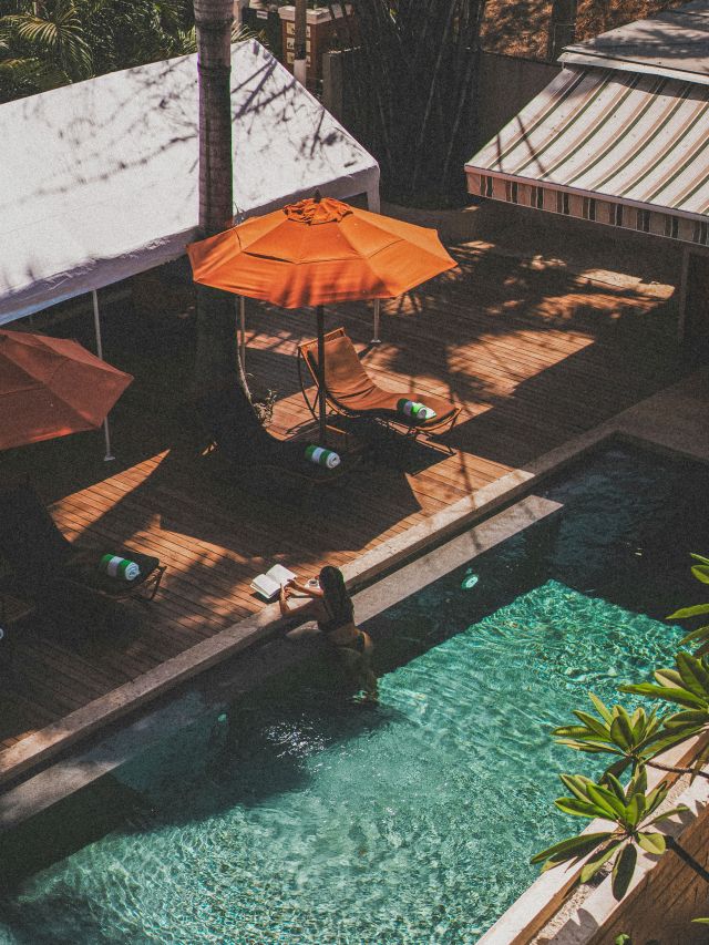a woman reading a book by the pool in Mallorca