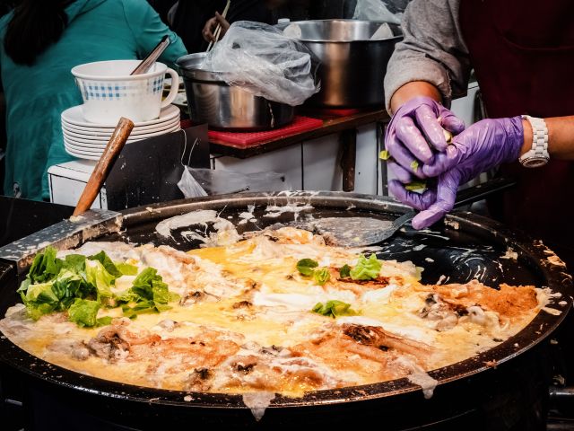 A vendor cooking oyster omelettes