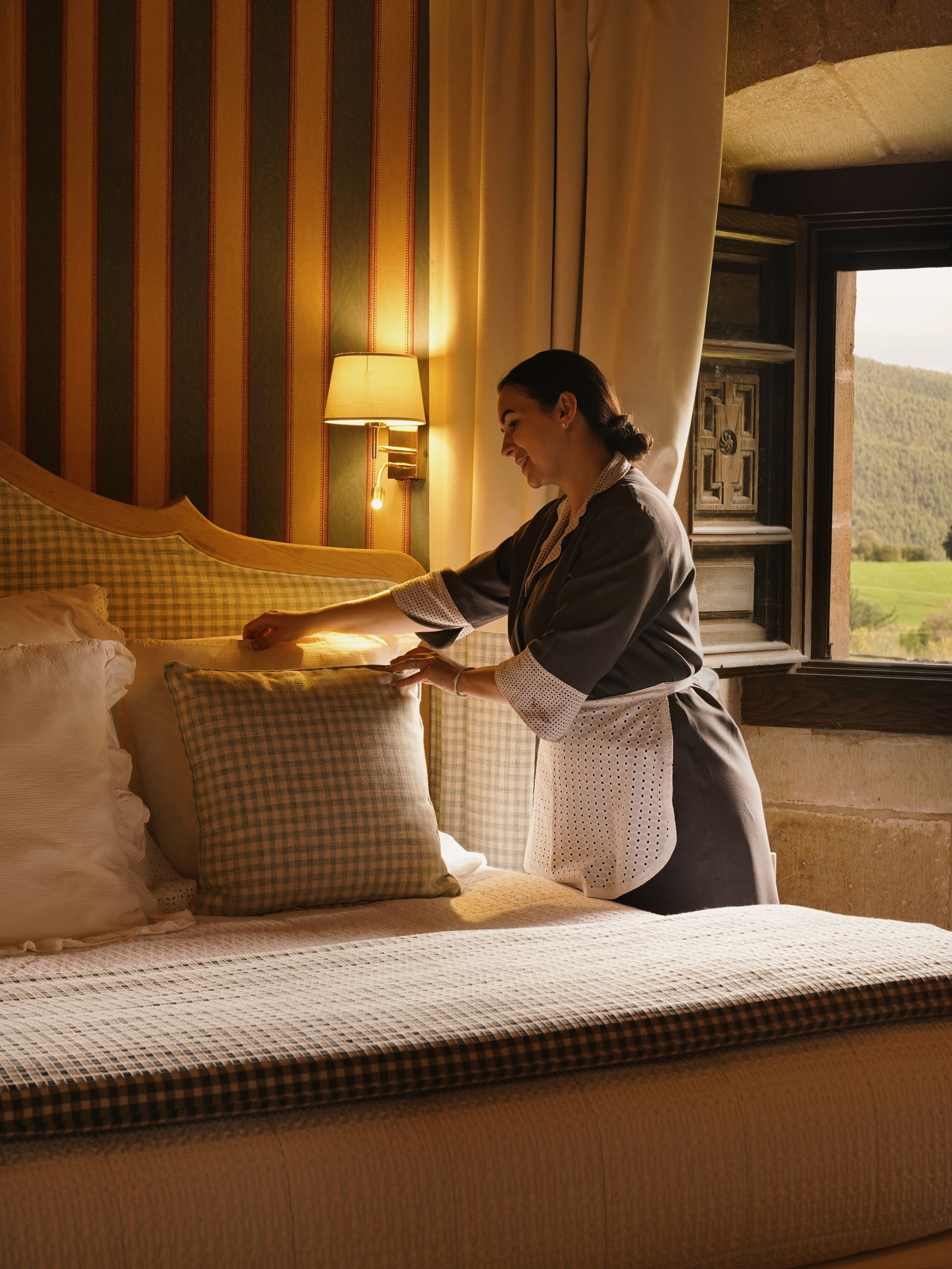 Housekeeper inside guest room at Helguera Palacio Boutique & Antique