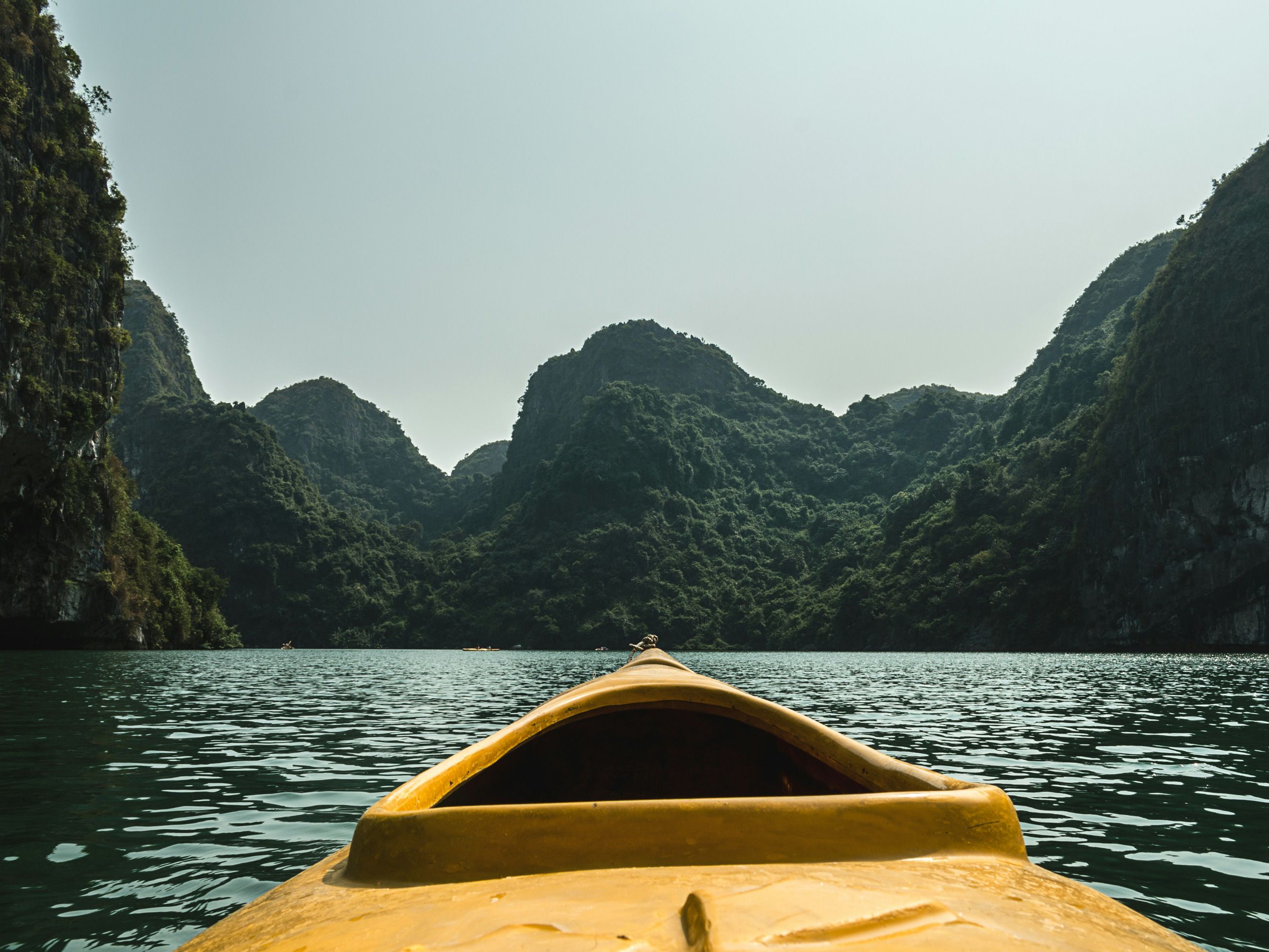 a kayak surrounded by scenic cliffs of Hạ Long Bay, Vietnam