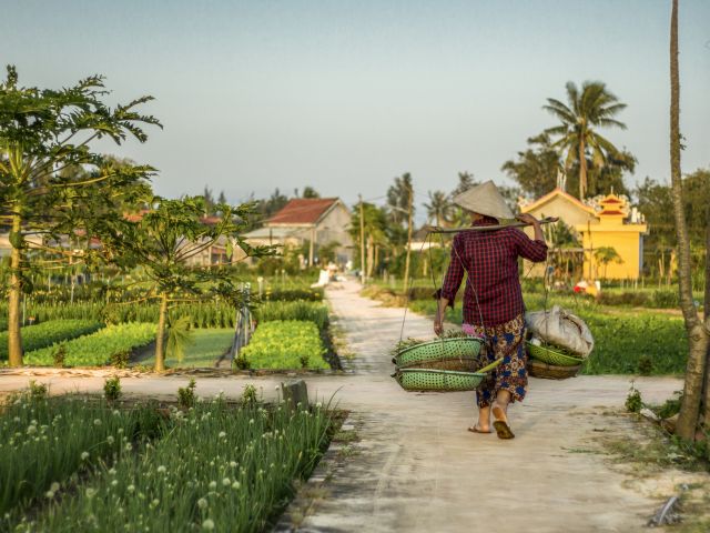 a farmer carrying baskets in Hội An, Vietnam